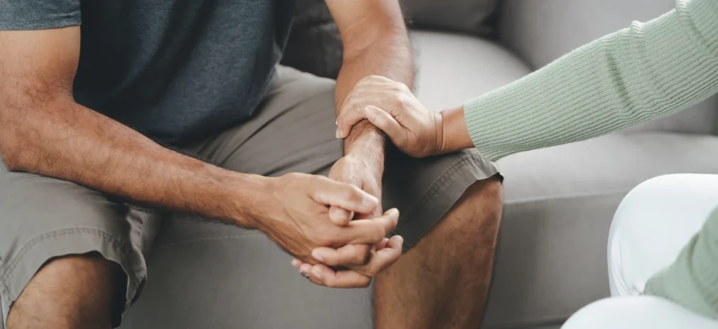 Close up of hands focused on a woman comforting a man